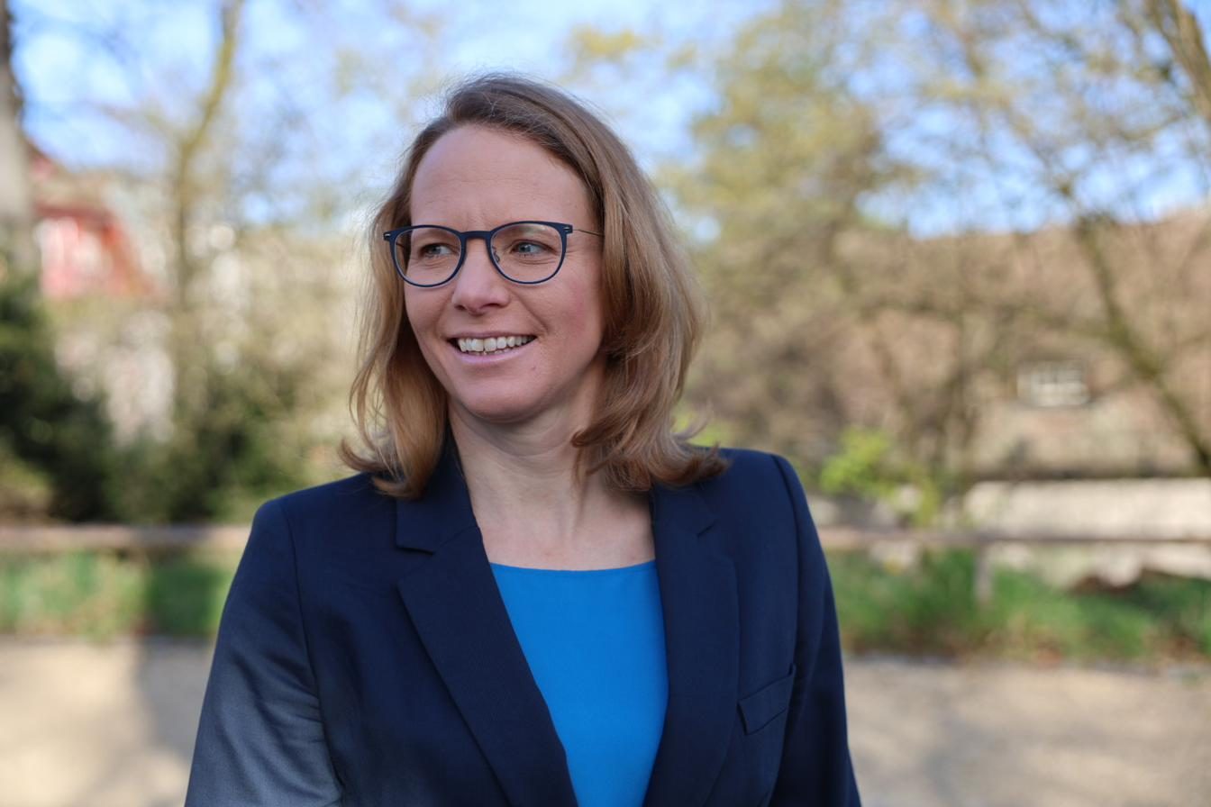 Laura Lanig im Freien, dunkelblauer Blazer, lächelnd